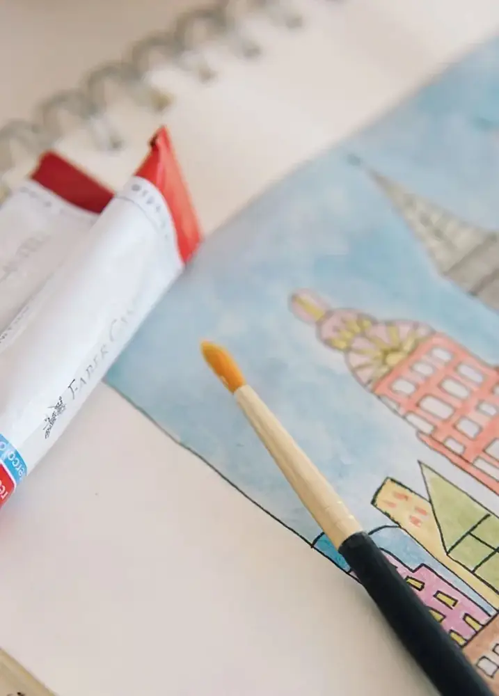 水彩で描かれた絵と筆、絵の具のチューブ